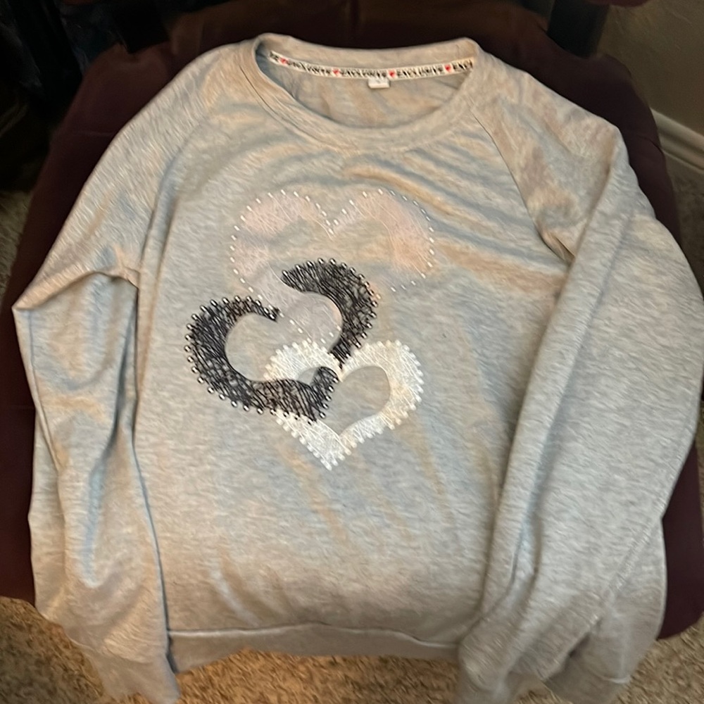 Grey sweatshirt w lavender, black & white hearts on front.